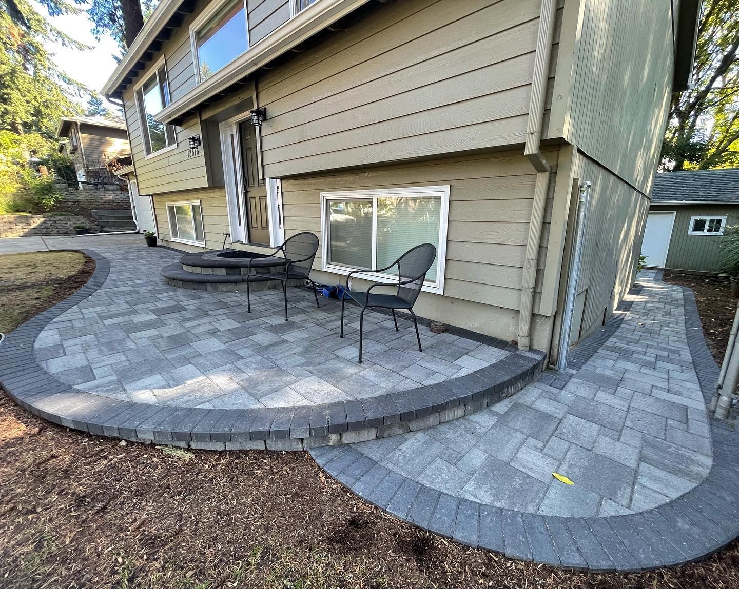 A patio with a table and chairs in front of a house.