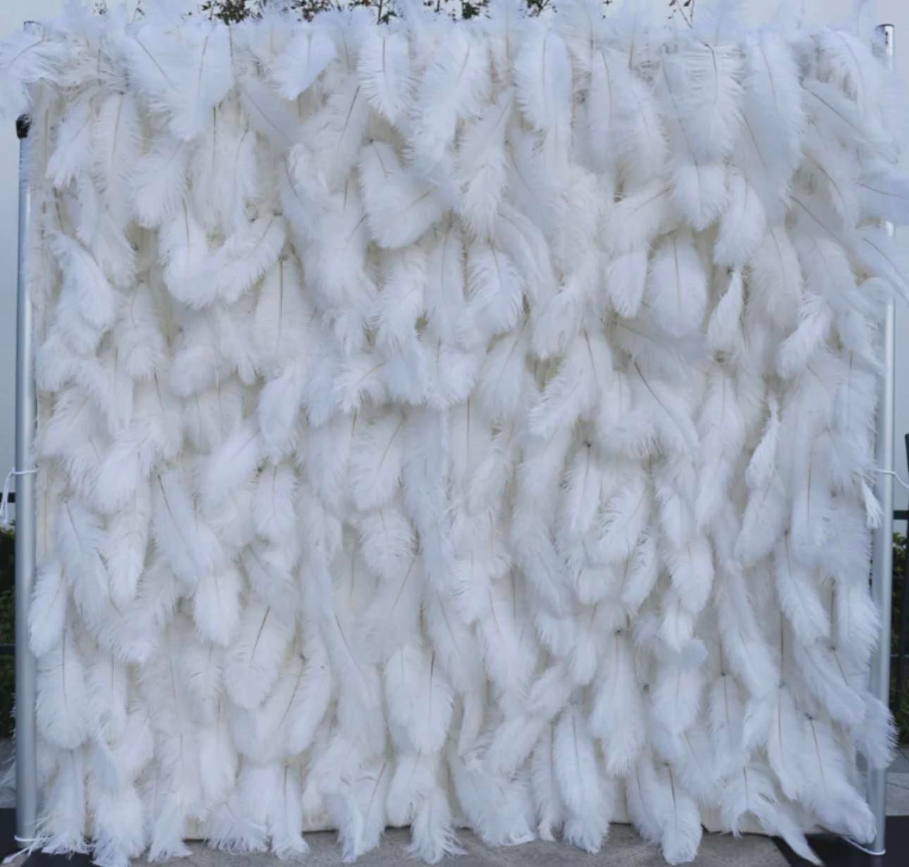 A wall of white feathers on a metal frame