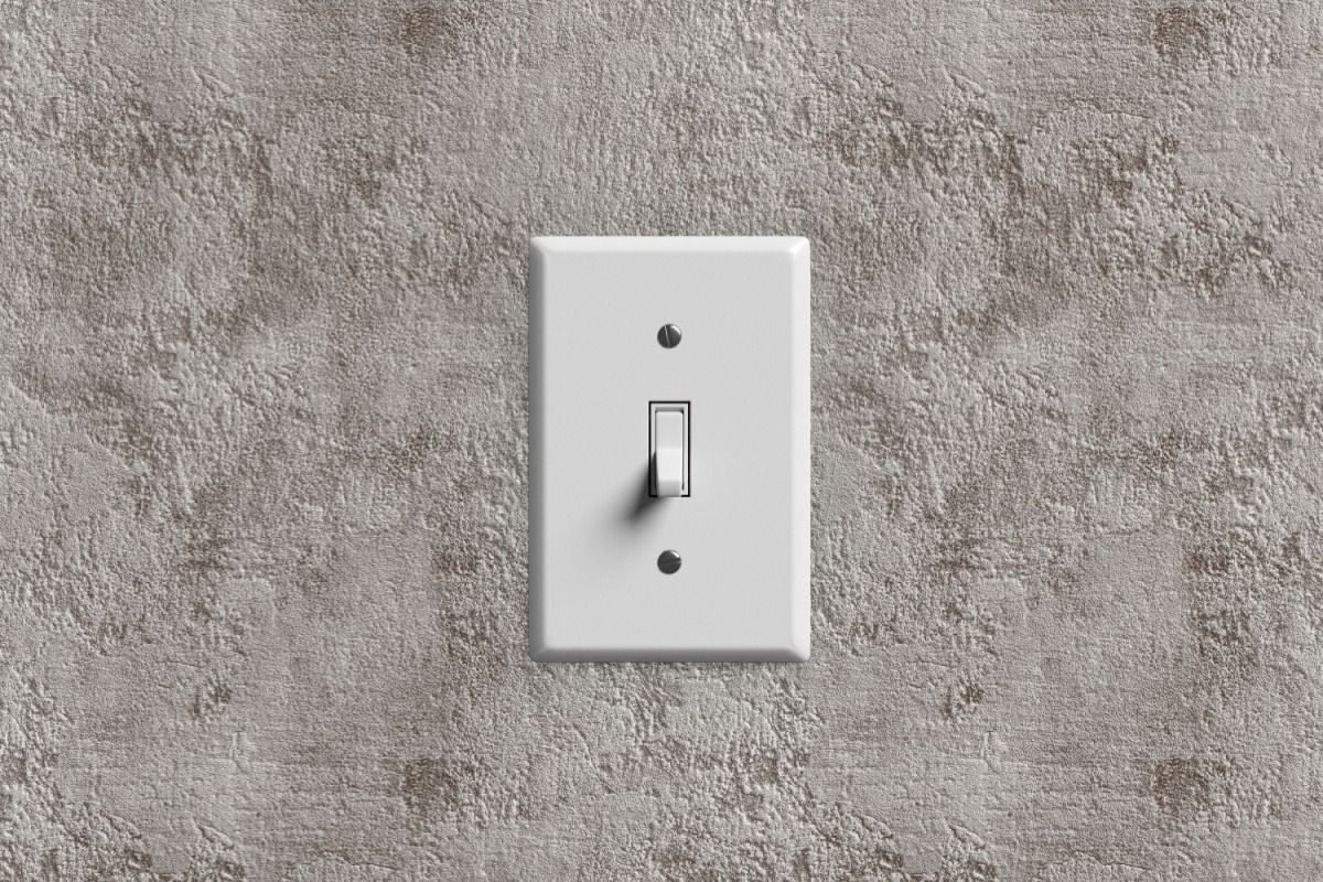 White light switch on a gray textured wall.