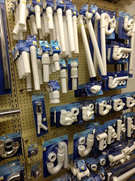 A bunch of white pipes are hanging on a wall