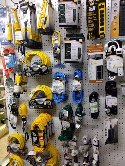 A wall filled with a variety of tools and electrical equipment.