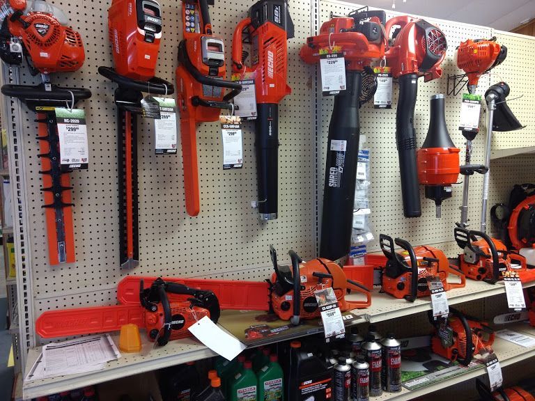 A display of tools including a chainsaw and a blower