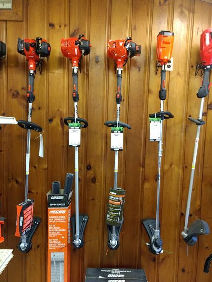 A row of trimmers hanging on a wooden wall