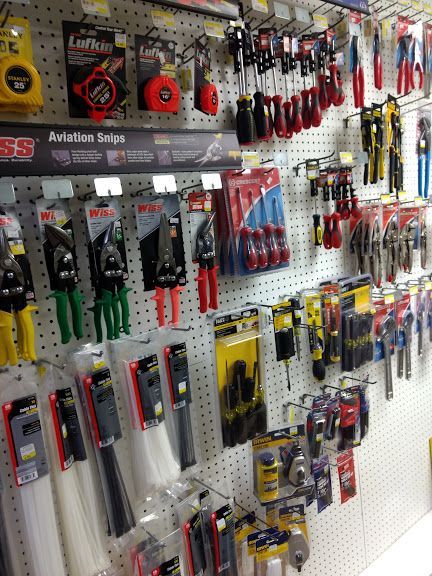 A bunch of tools are hanging on a wall in a store