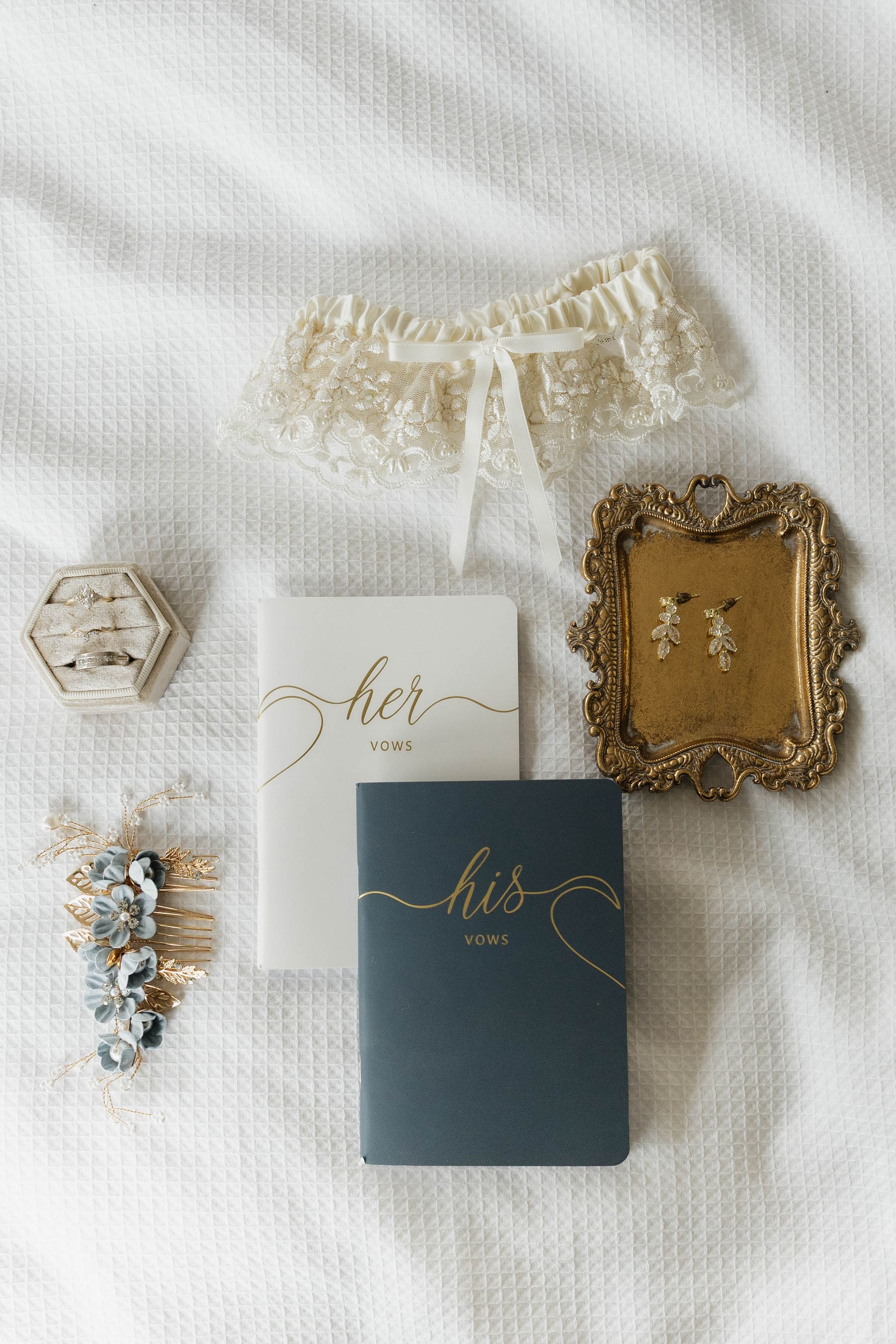 White lace lingerie set with a blue invitation card and small decorative accessories on a white background