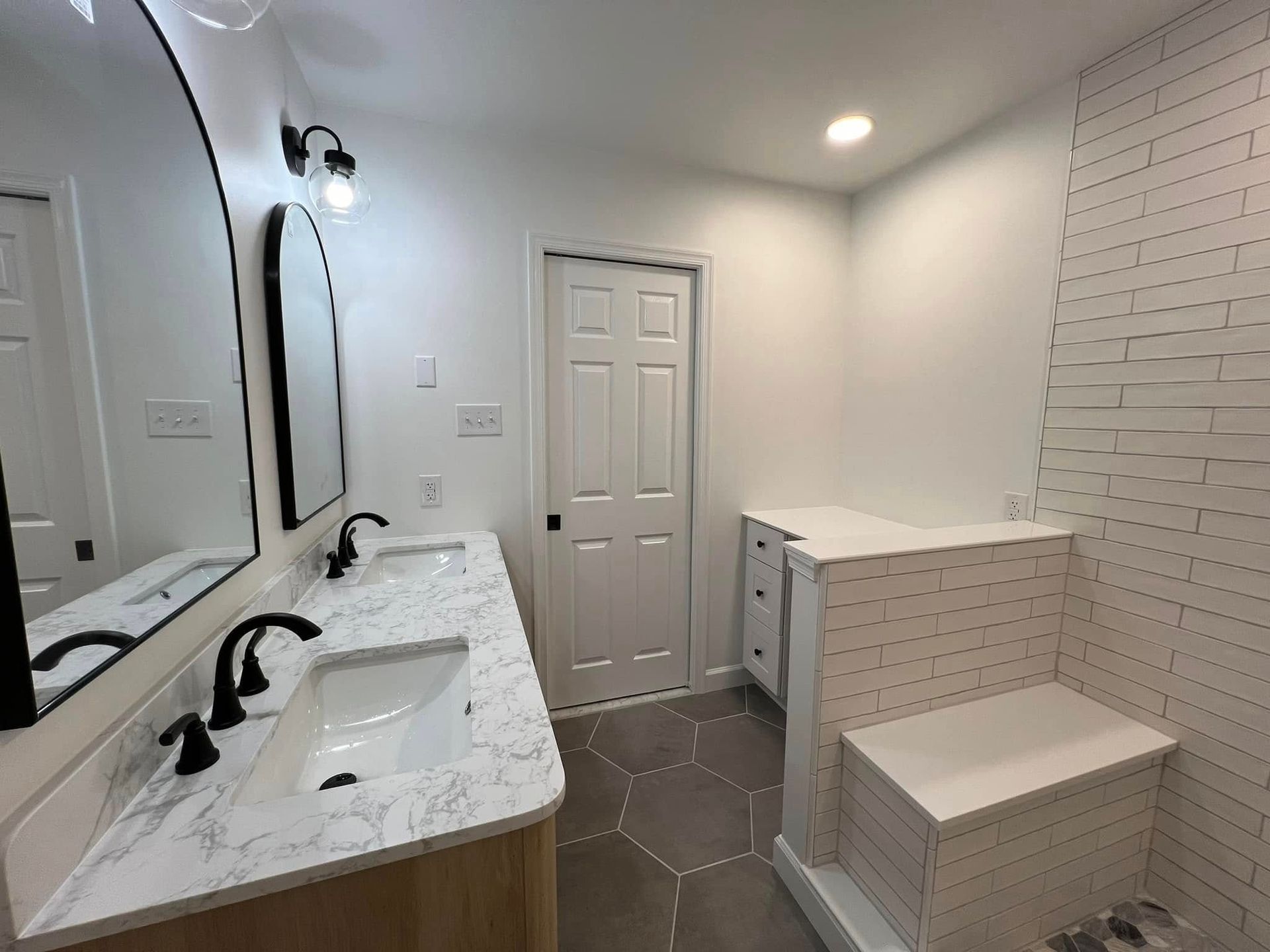 A bathroom with two sinks, a mirror and a bathtub.
