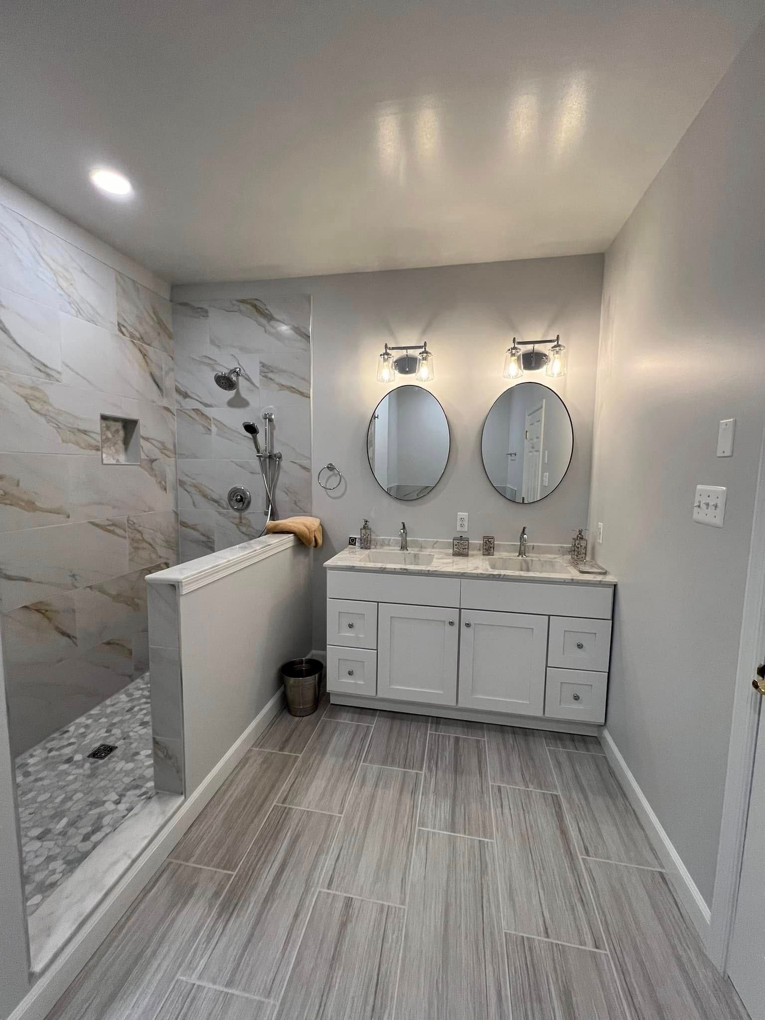 A bathroom with two sinks and a walk in shower.