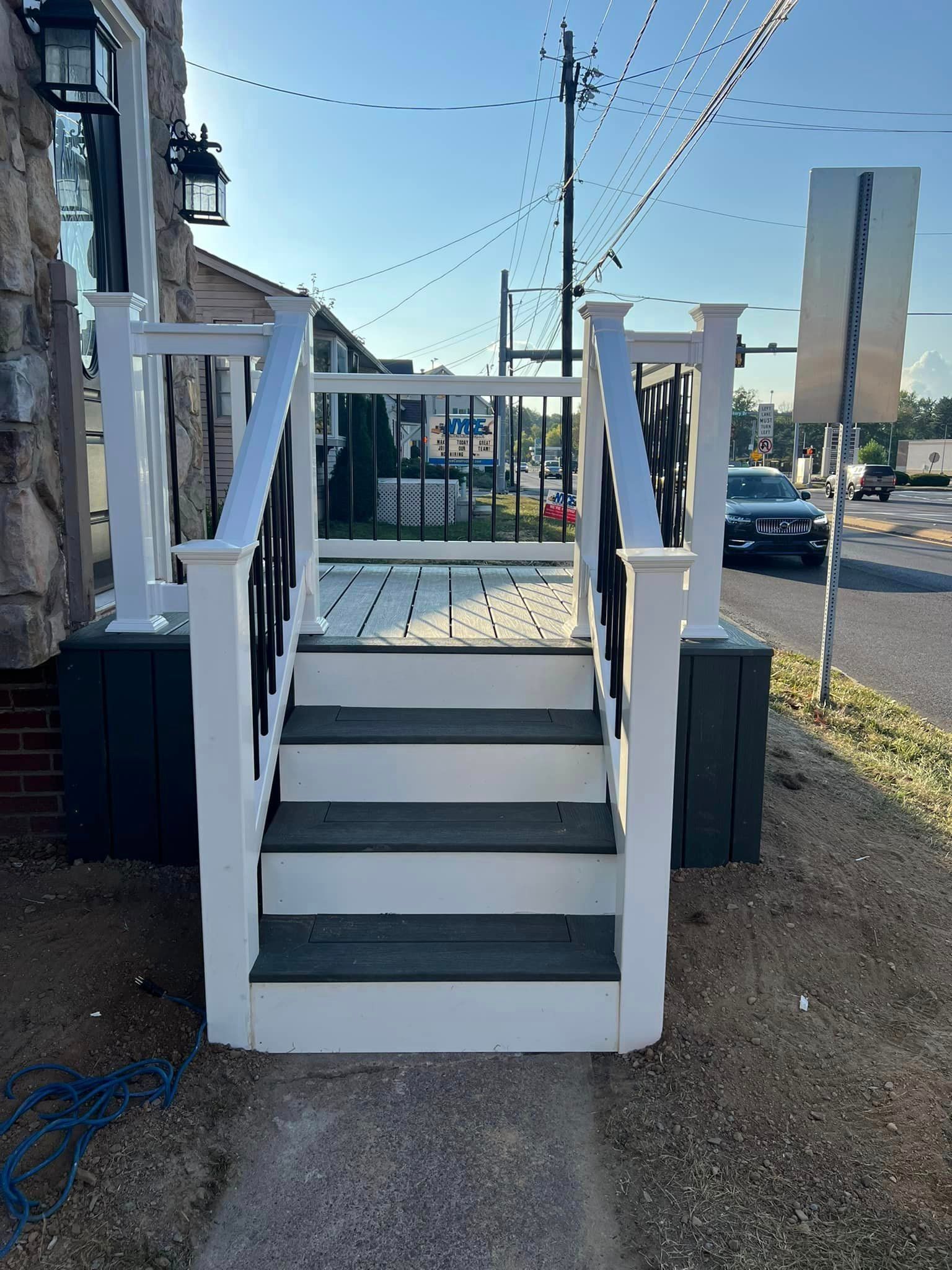 A set of stairs leading up to a porch on the side of a building.