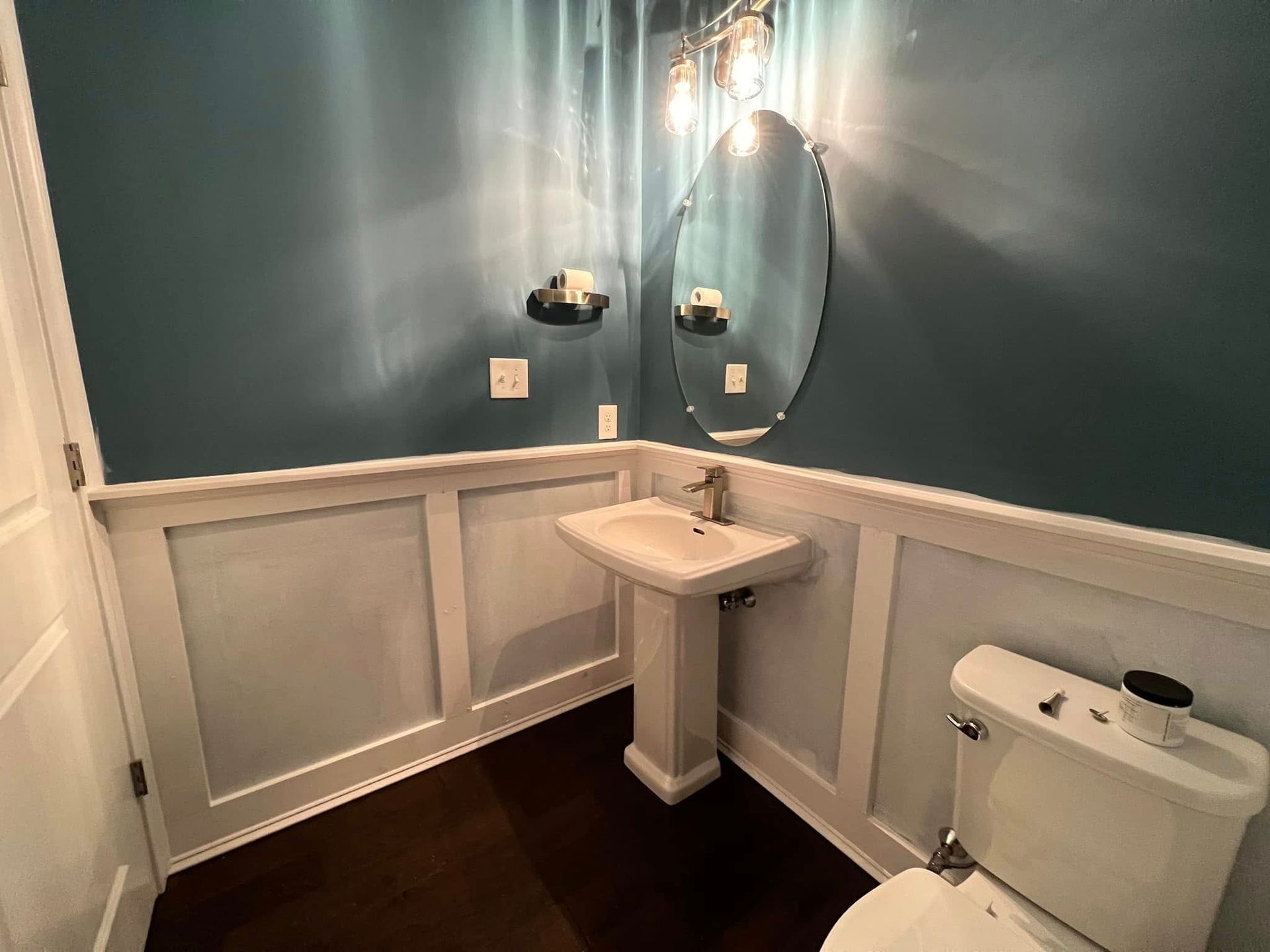 A bathroom with a sink, toilet, and mirror.