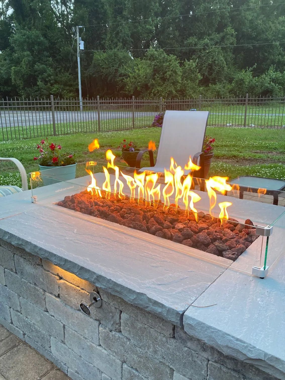 a fire pit is sitting on top of a brick wall