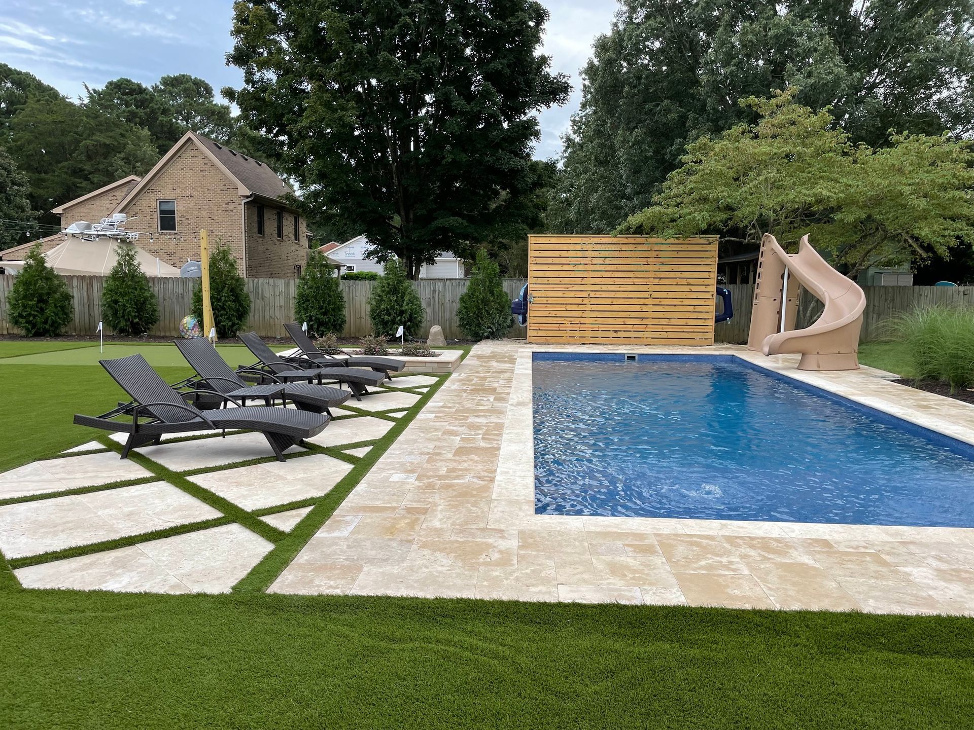 there is a large swimming pool in the backyard with a slide