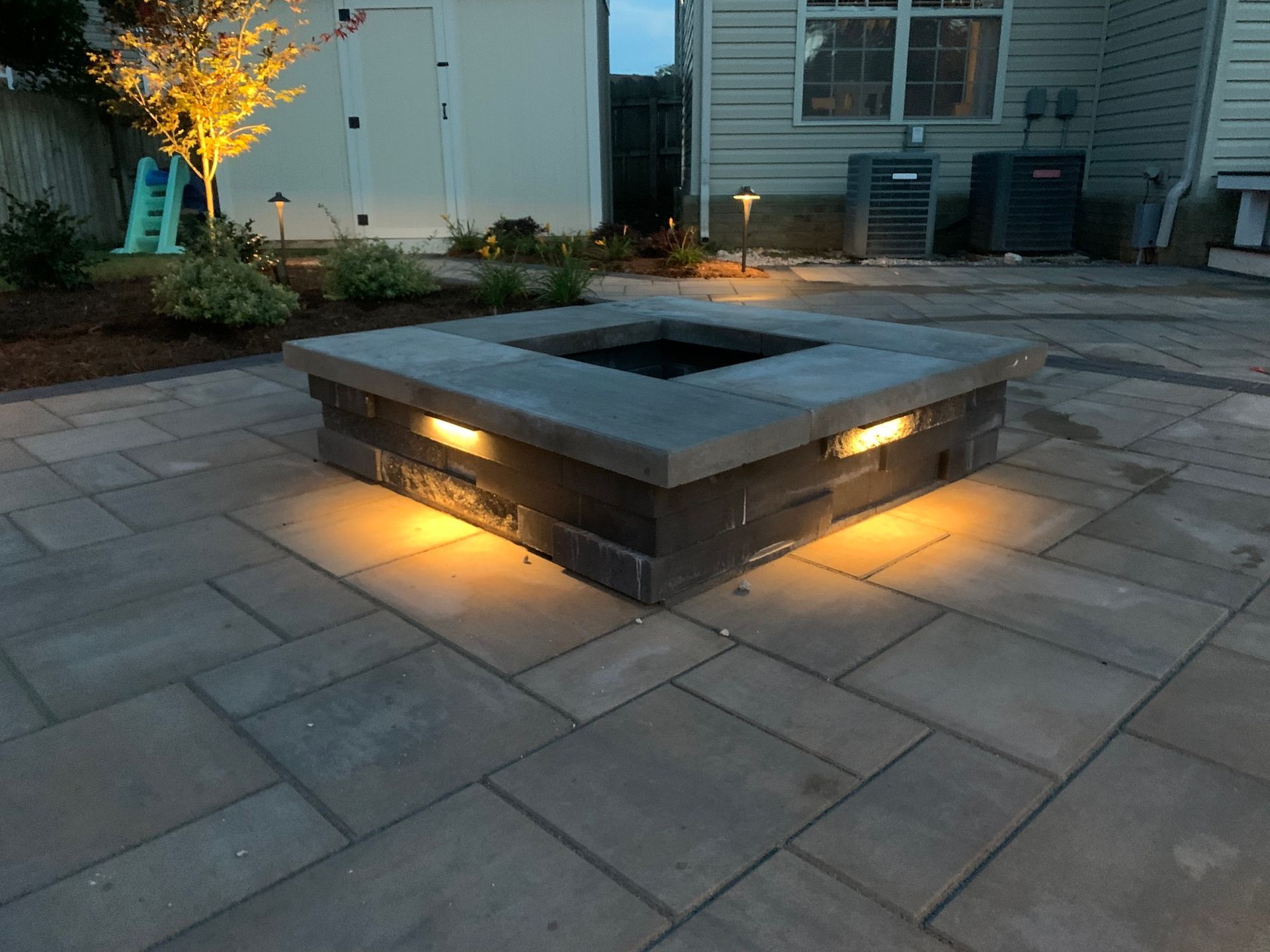a fire pit is lit up at night on a patio