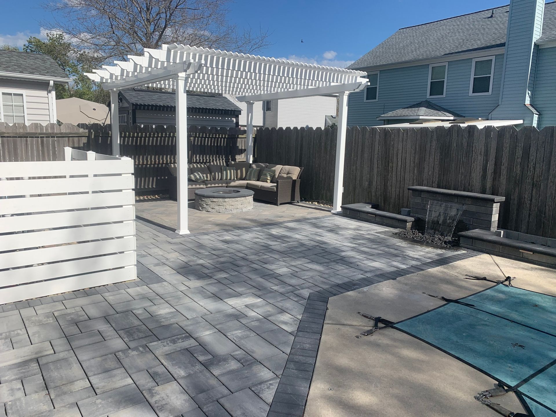a patio with a pergola and a pool in the backyard of a house