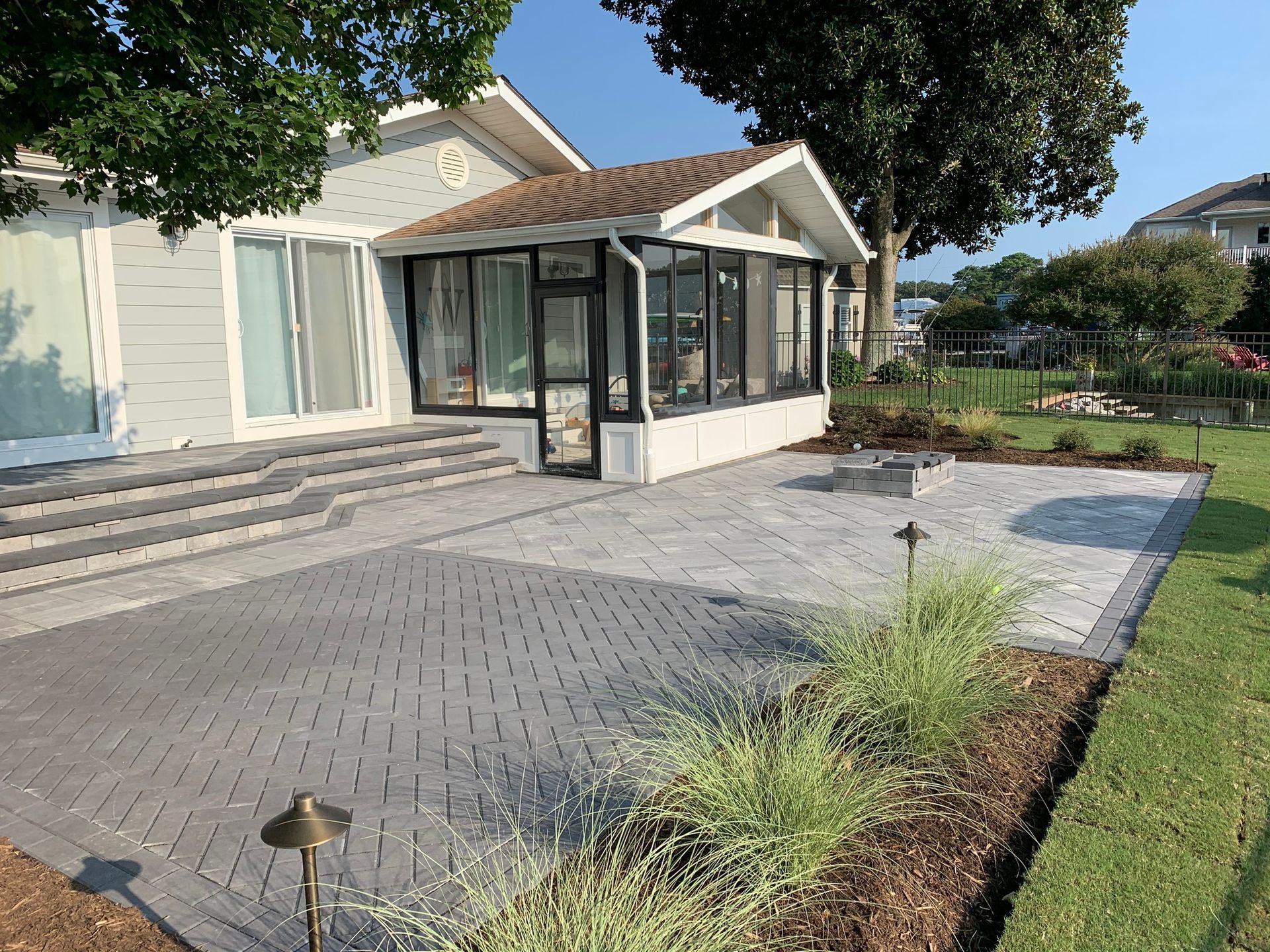 a house with a screened in porch and a patio in front of it