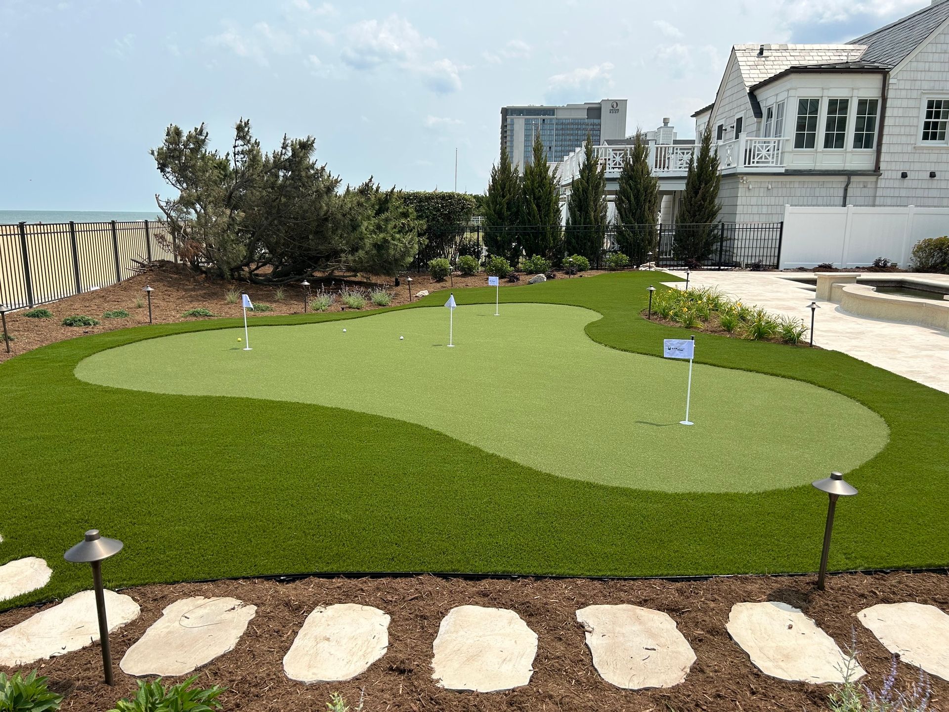 a putting green in a backyard with a house in the background