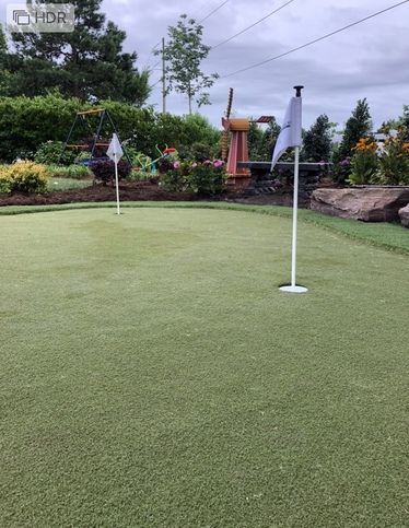 a golf course with a white flag on the green