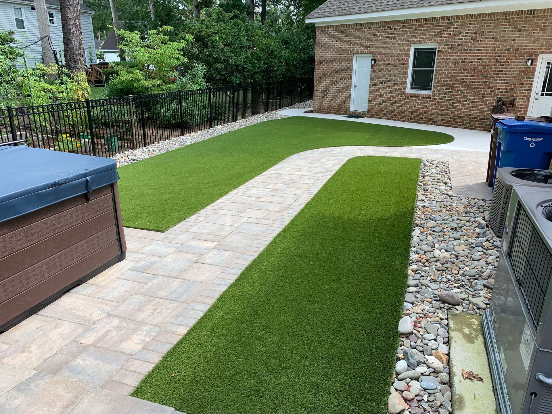 a brick walkway leading to a hot tub in a backyard