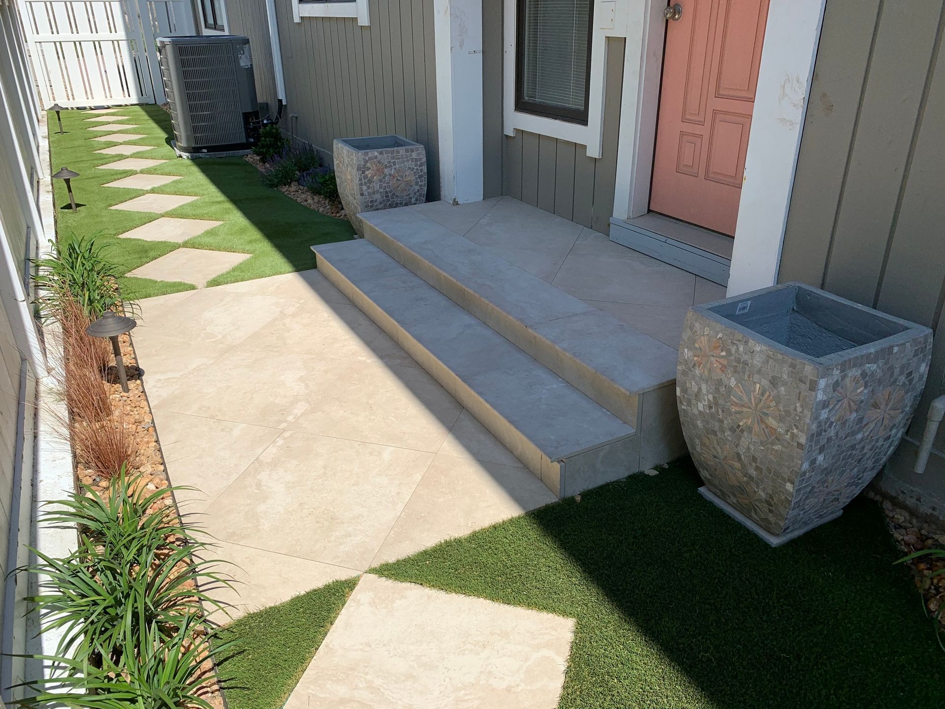 a stone pot sits on the grass in front of a house