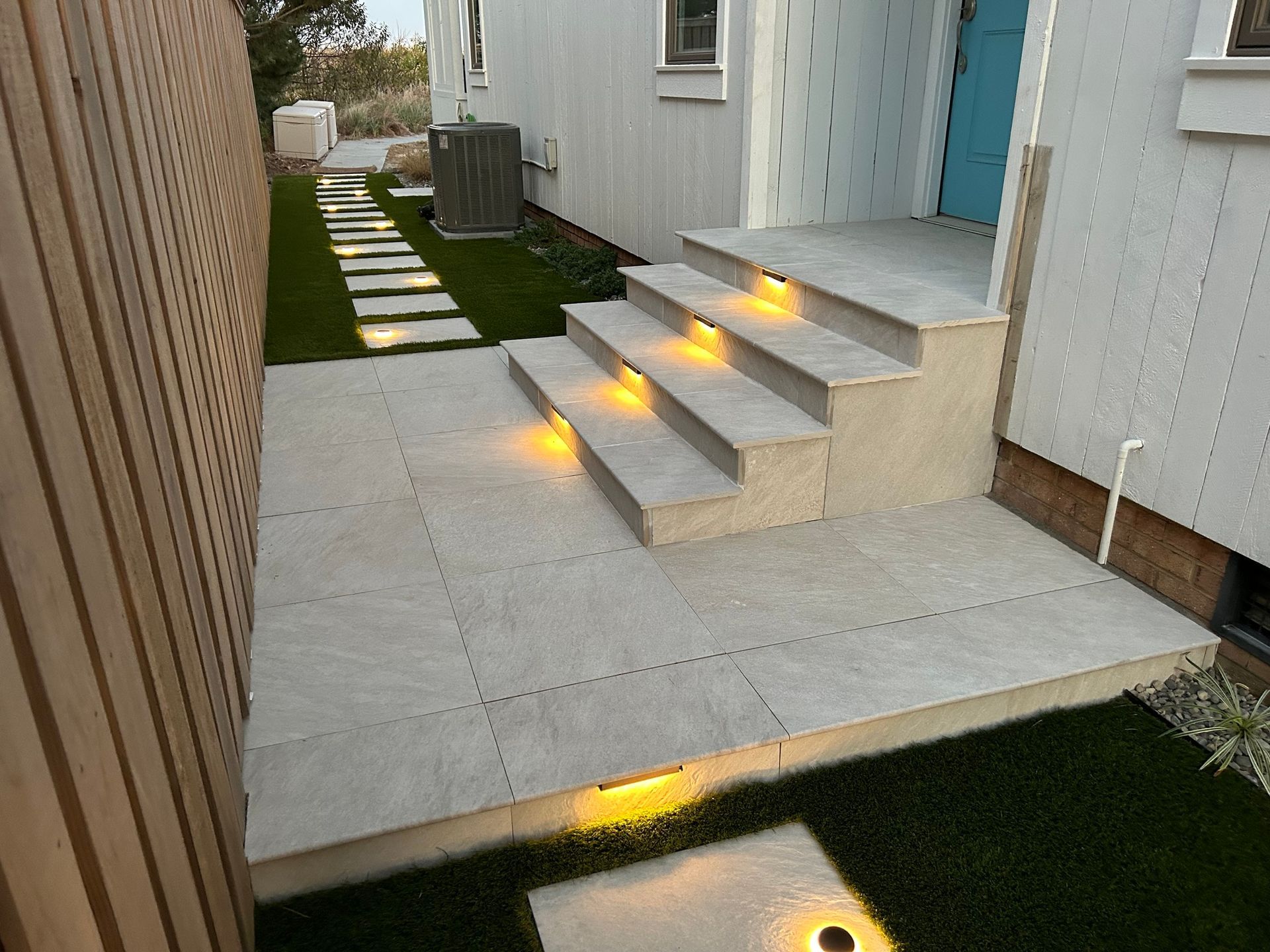 a set of stairs leading up to a house with lights on them