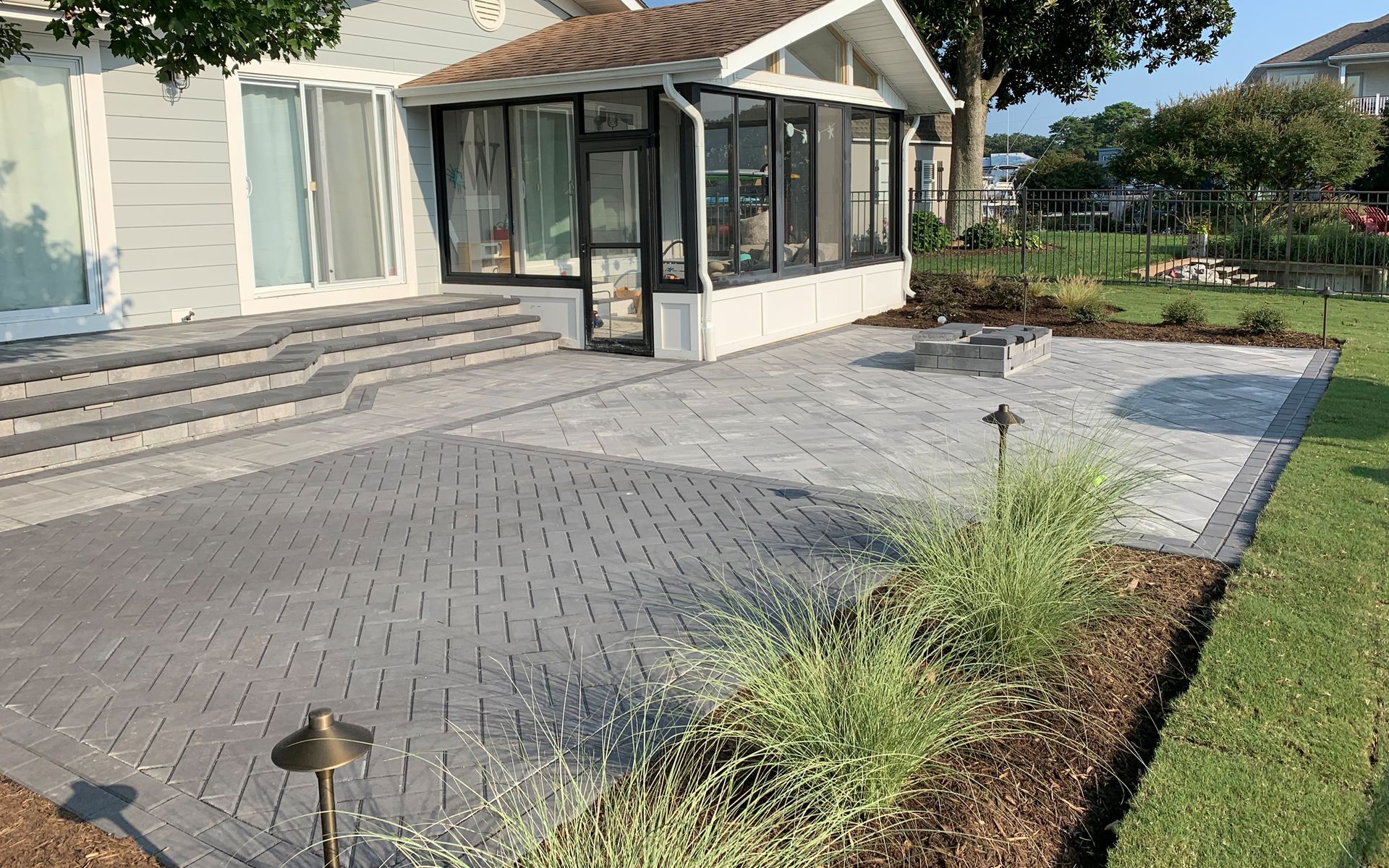 a house with a screened in porch and a patio in front of it
