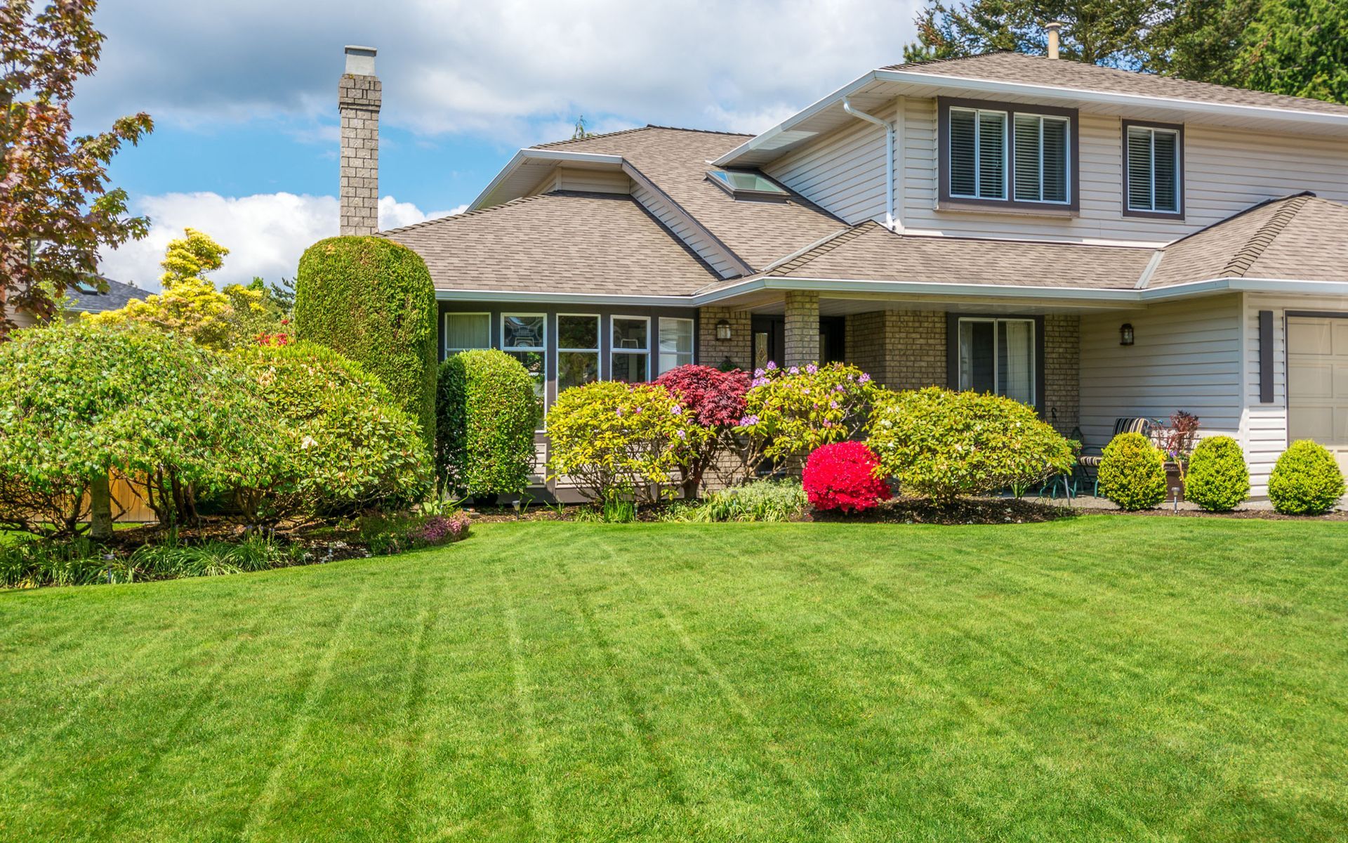 a large white house with a lush green lawn in front of it
