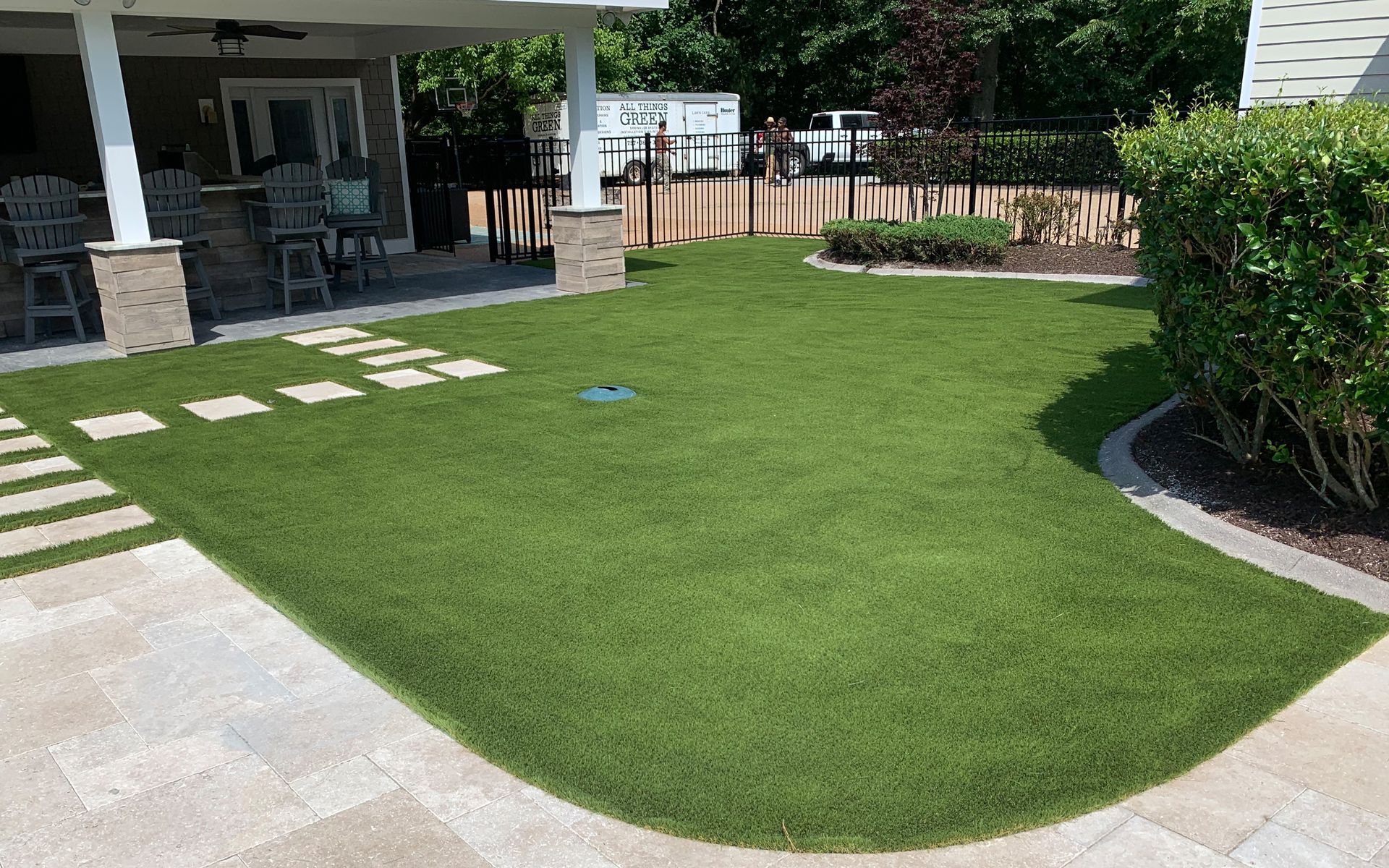a lush green lawn in front of a house with a patio