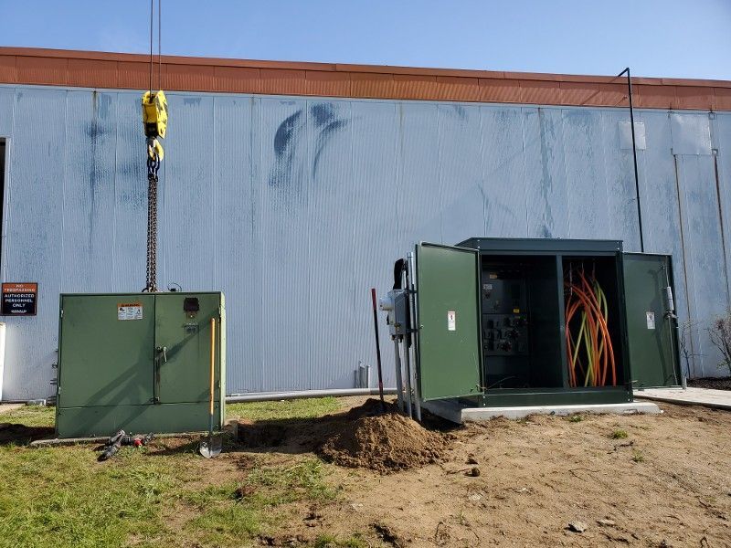A transformer is being installed in front of a building.