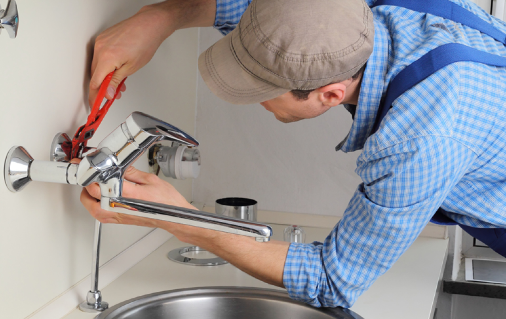 Plumber installing the kitchen faucet
