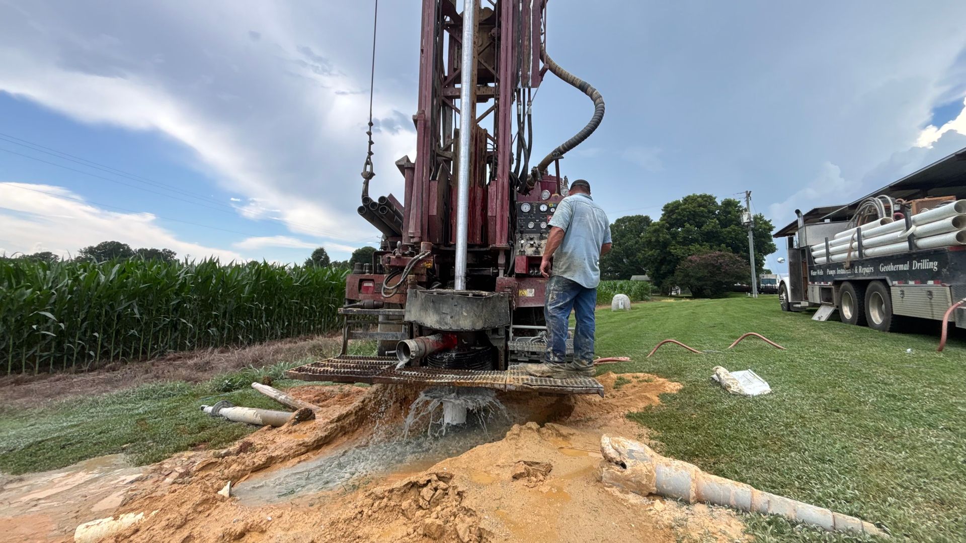 A man is standing next to a large machine in a field.