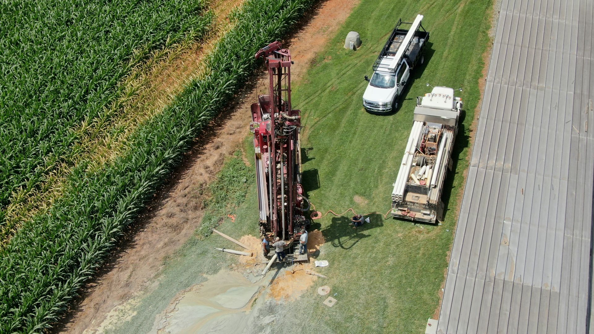 An aerial view of a water well being drilled in a field.