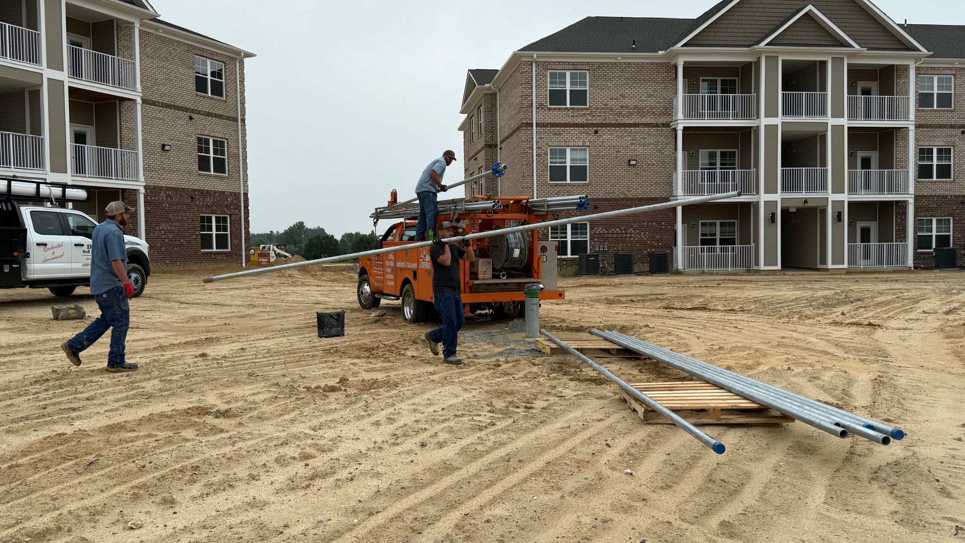 A group of people are working on a construction site in front of a building.