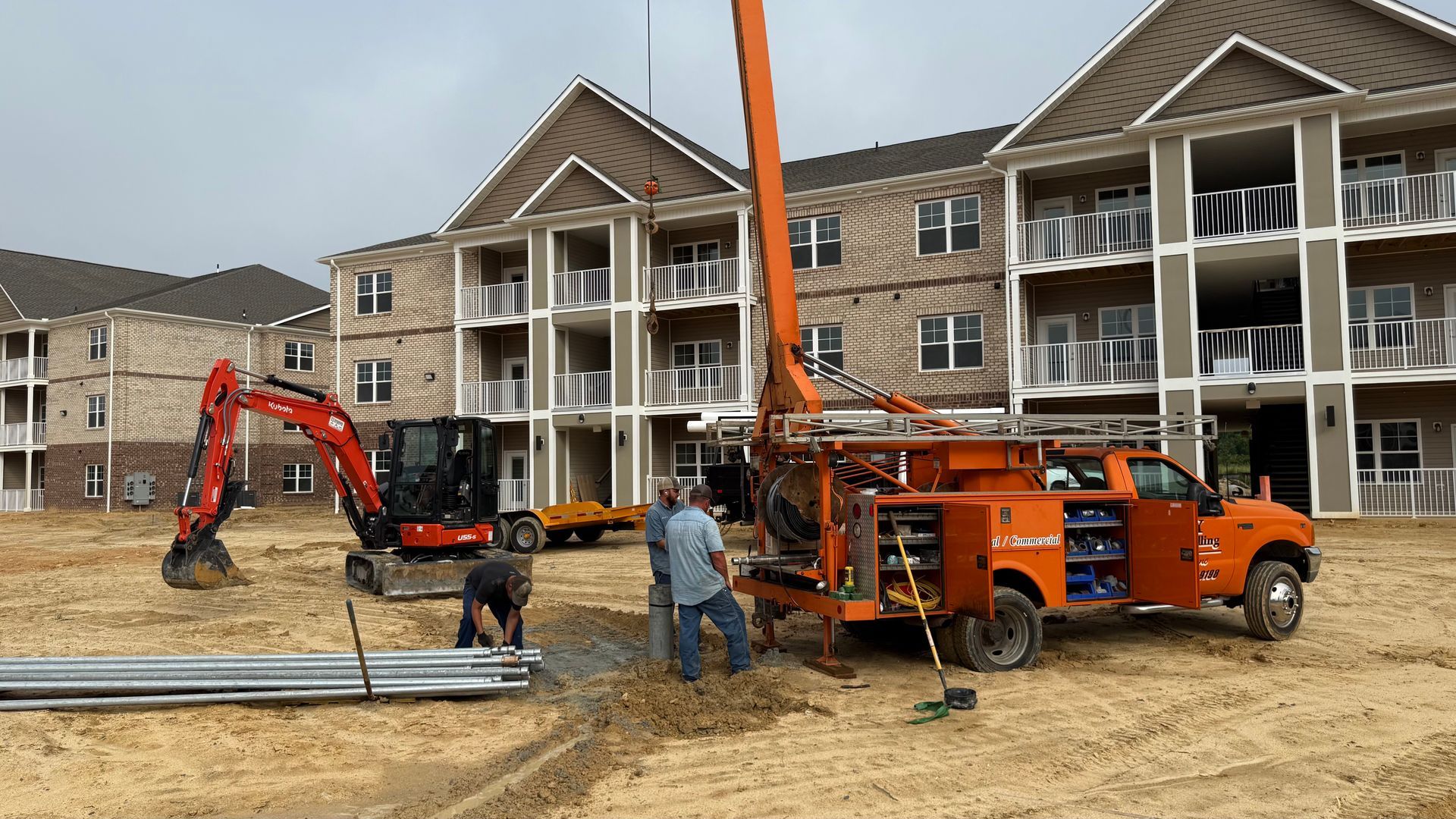 A group of construction workers are working on a construction site in front of a building.