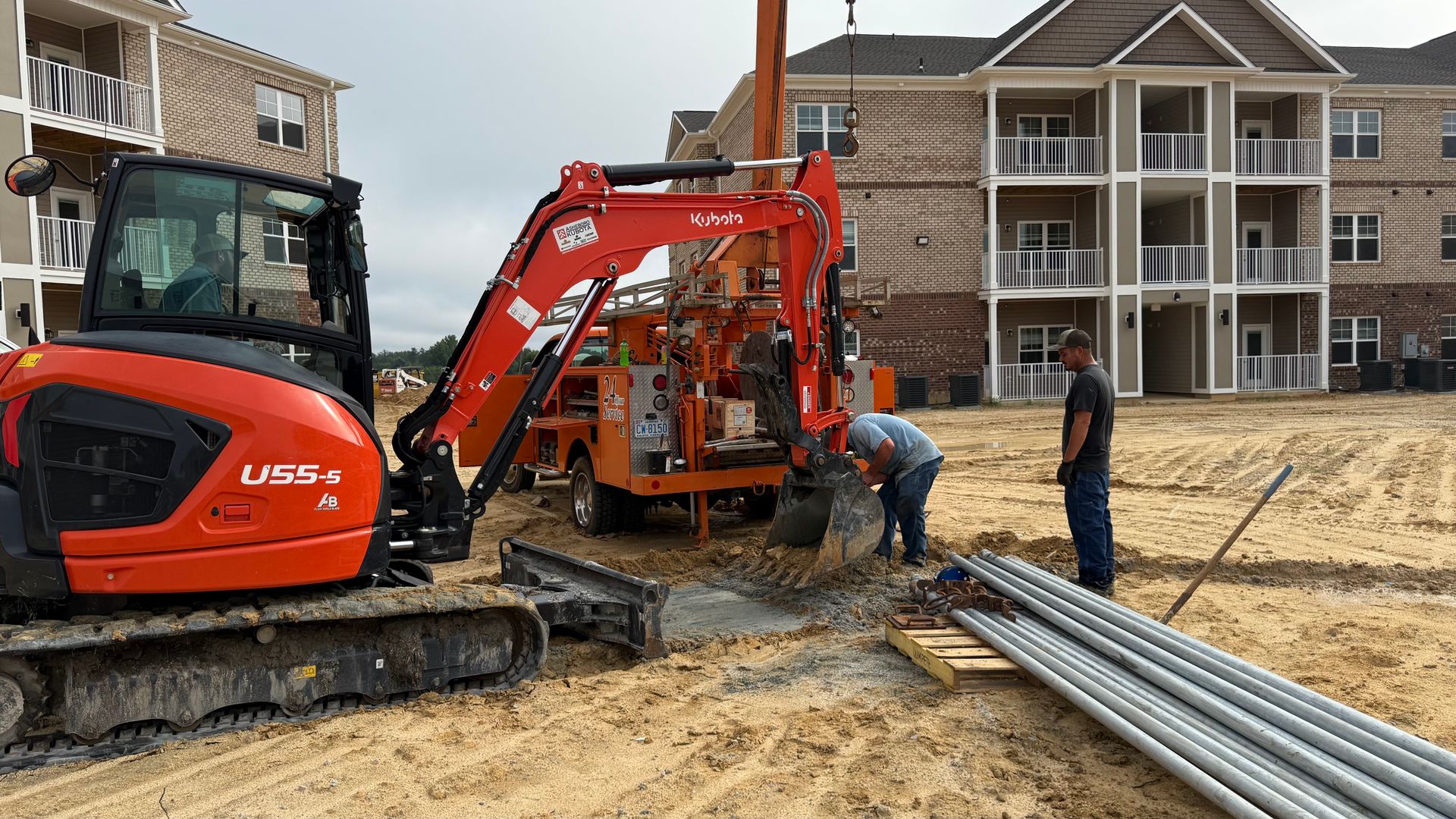 A group of construction workers are working on a construction site in front of a building.