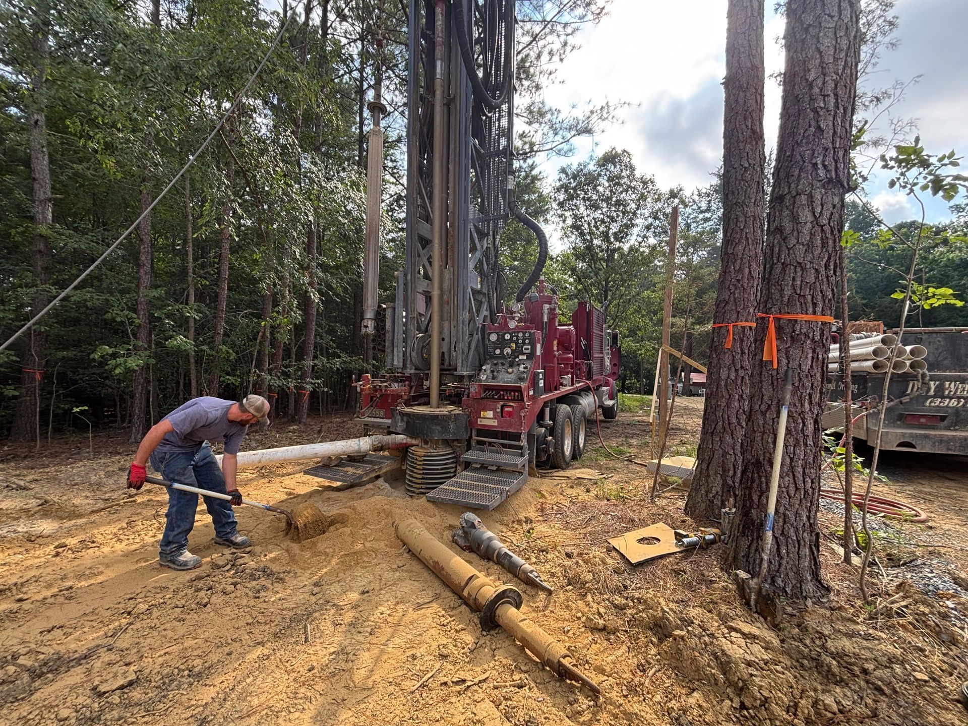 A man is working on a drilling rig in the woods.