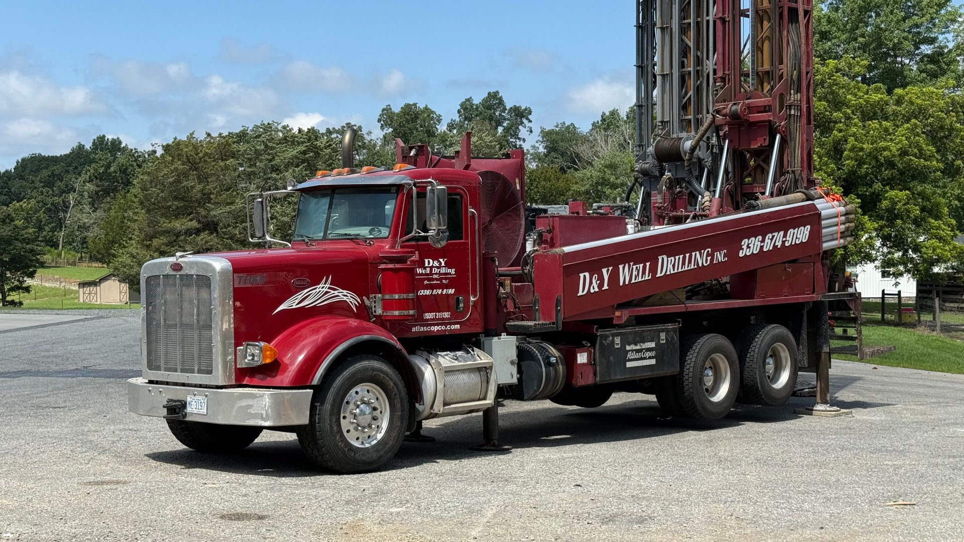 A yellow truck is drilling a hole in the ground.
