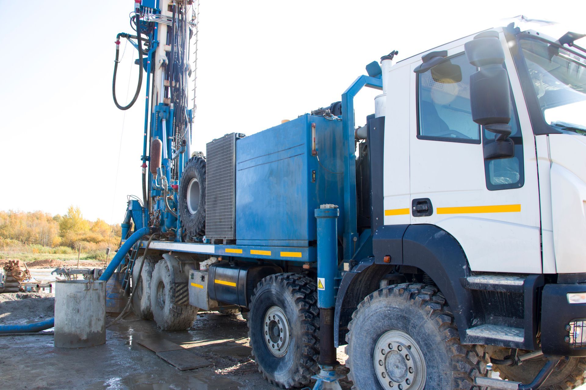 A blue and white truck with a water pump attached to it.