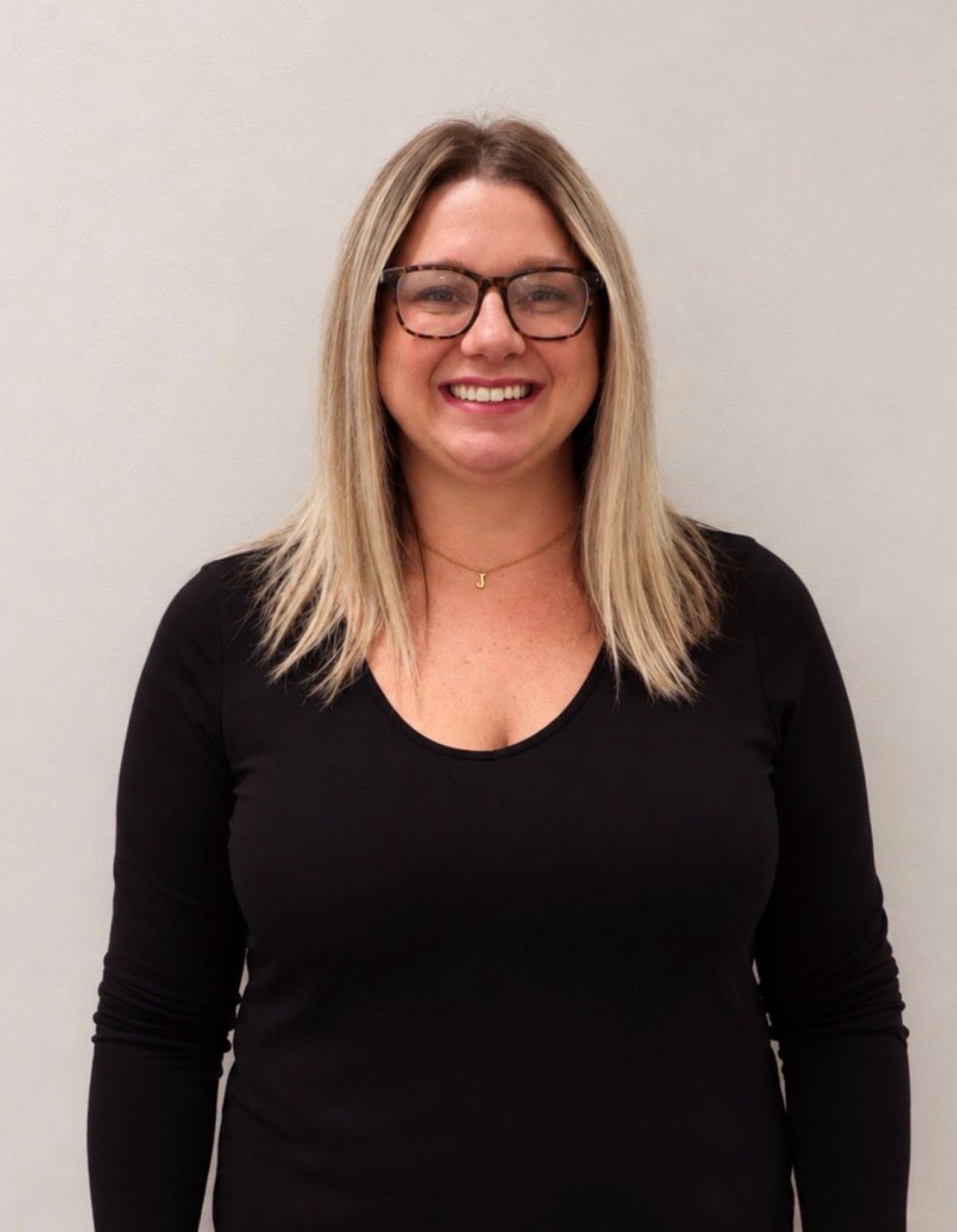 Blonde woman with glasses smiling