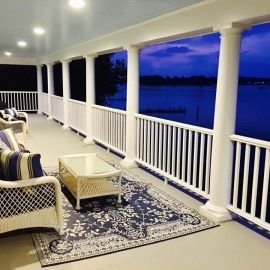 There is a large porch with a view of the water.