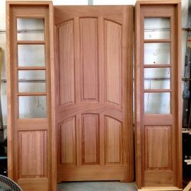 A set of wooden doors with glass in a room.