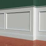 White wainscoting panels on a wall, meeting a corner, with a green upper wall and brown wooden floor.