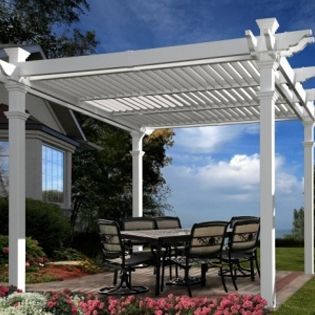 A white pergola with a table and chairs underneath it