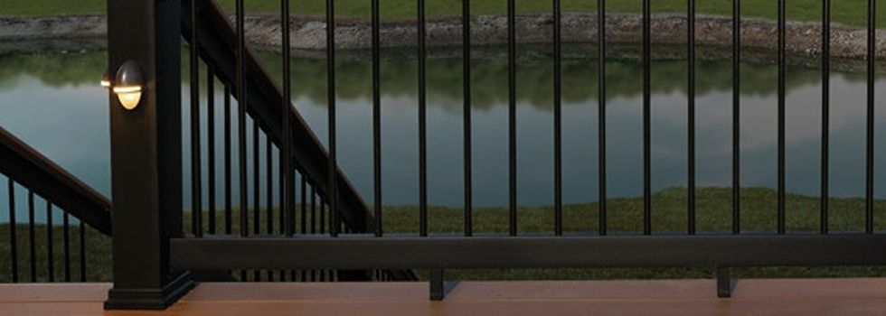 A black railing on a deck overlooking a body of water.