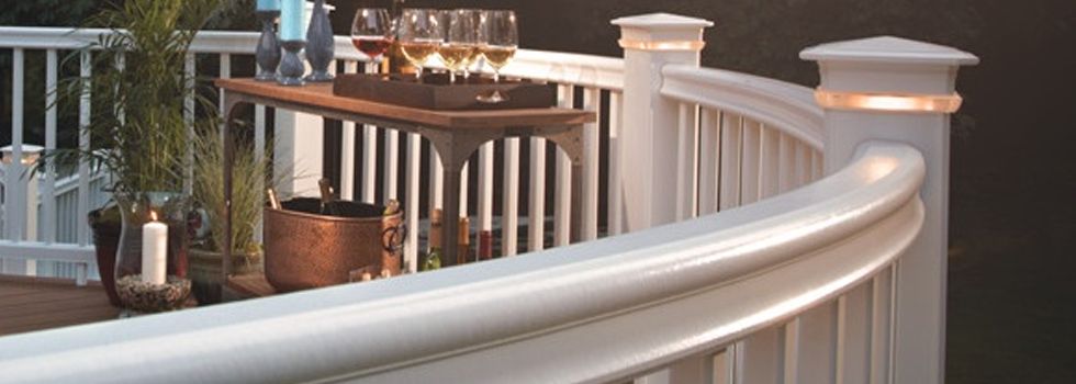 A white railing with a tray of wine glasses on it.