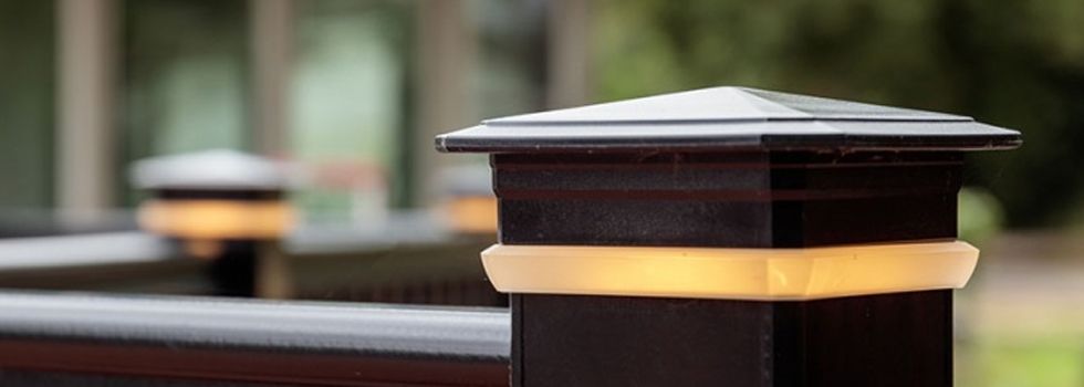 A close up of a wooden post with a light on it.