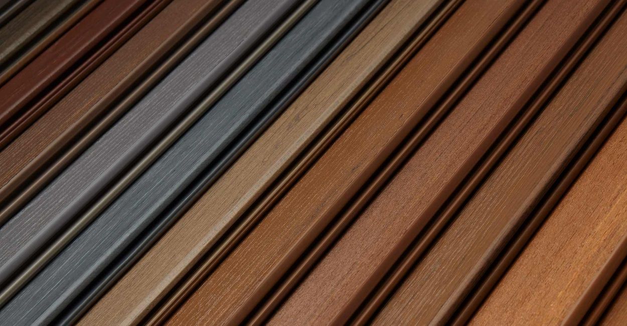 Diagonal arrangement of wooden planks in various shades of brown and gray. The planks are grooved.