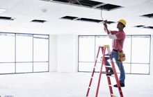 Electrician installing fluorescent light to a commercial space