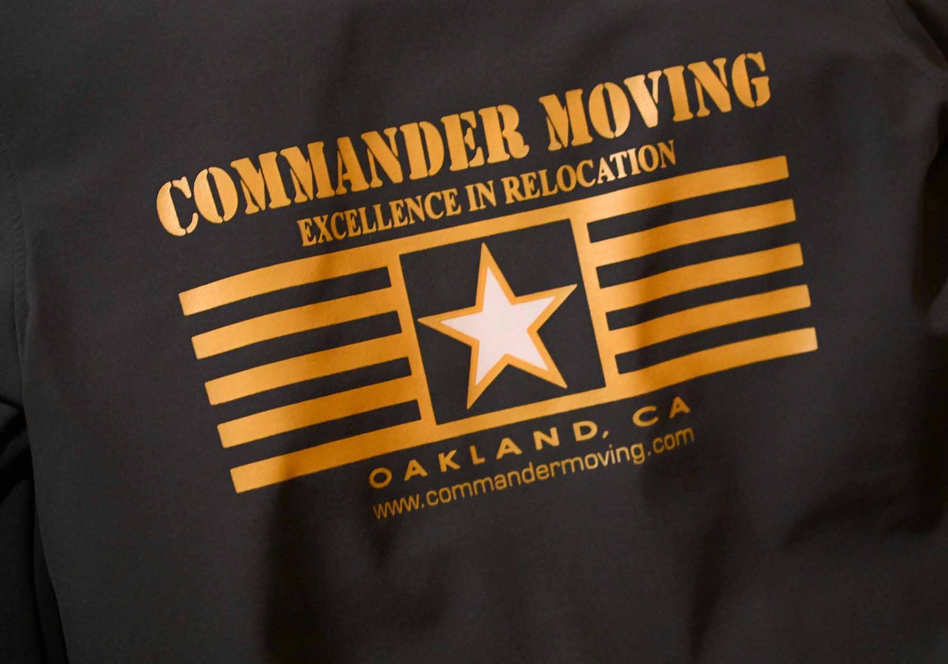 Black jacket with gold text and graphic: 