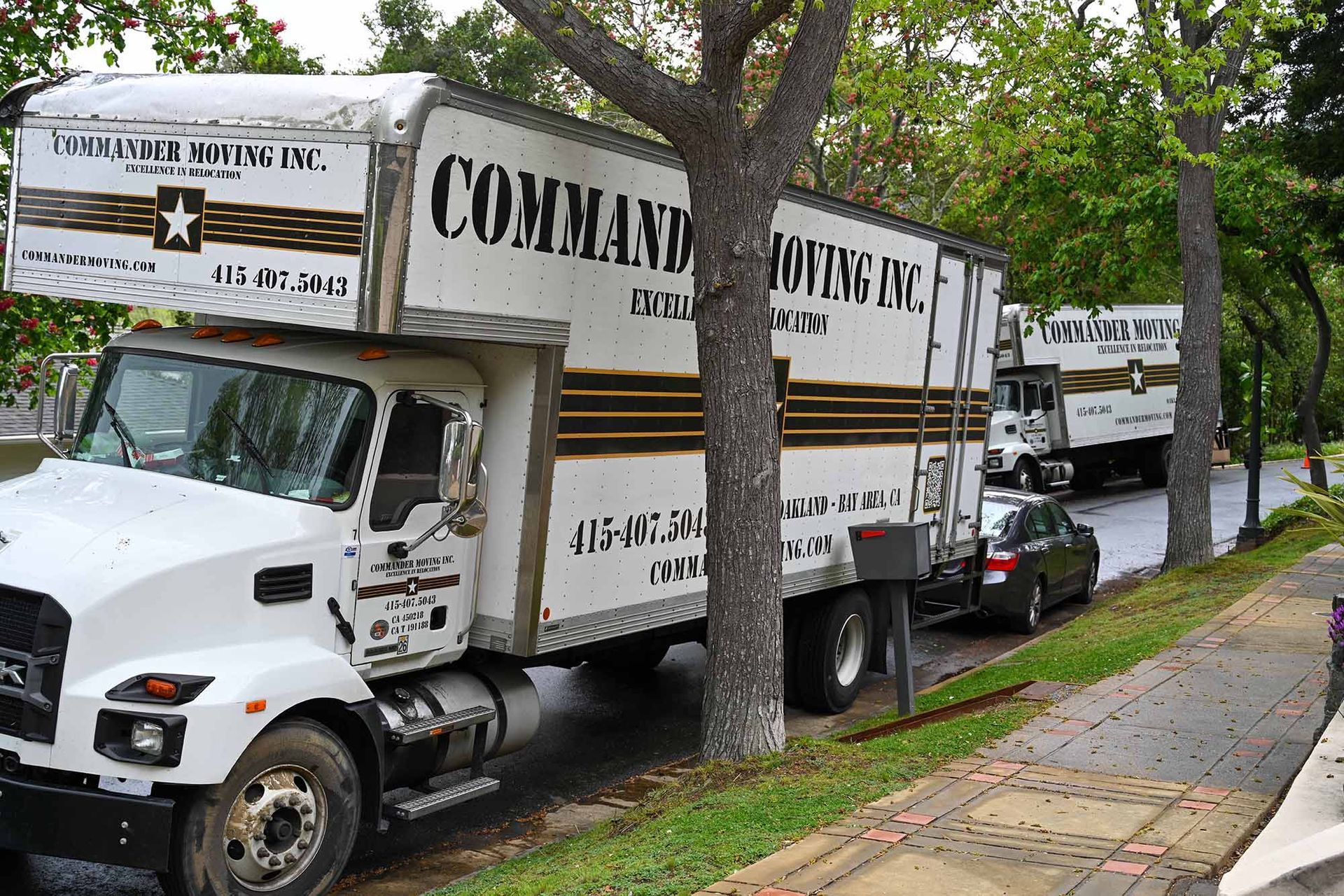 White moving truck parked on a street, with 