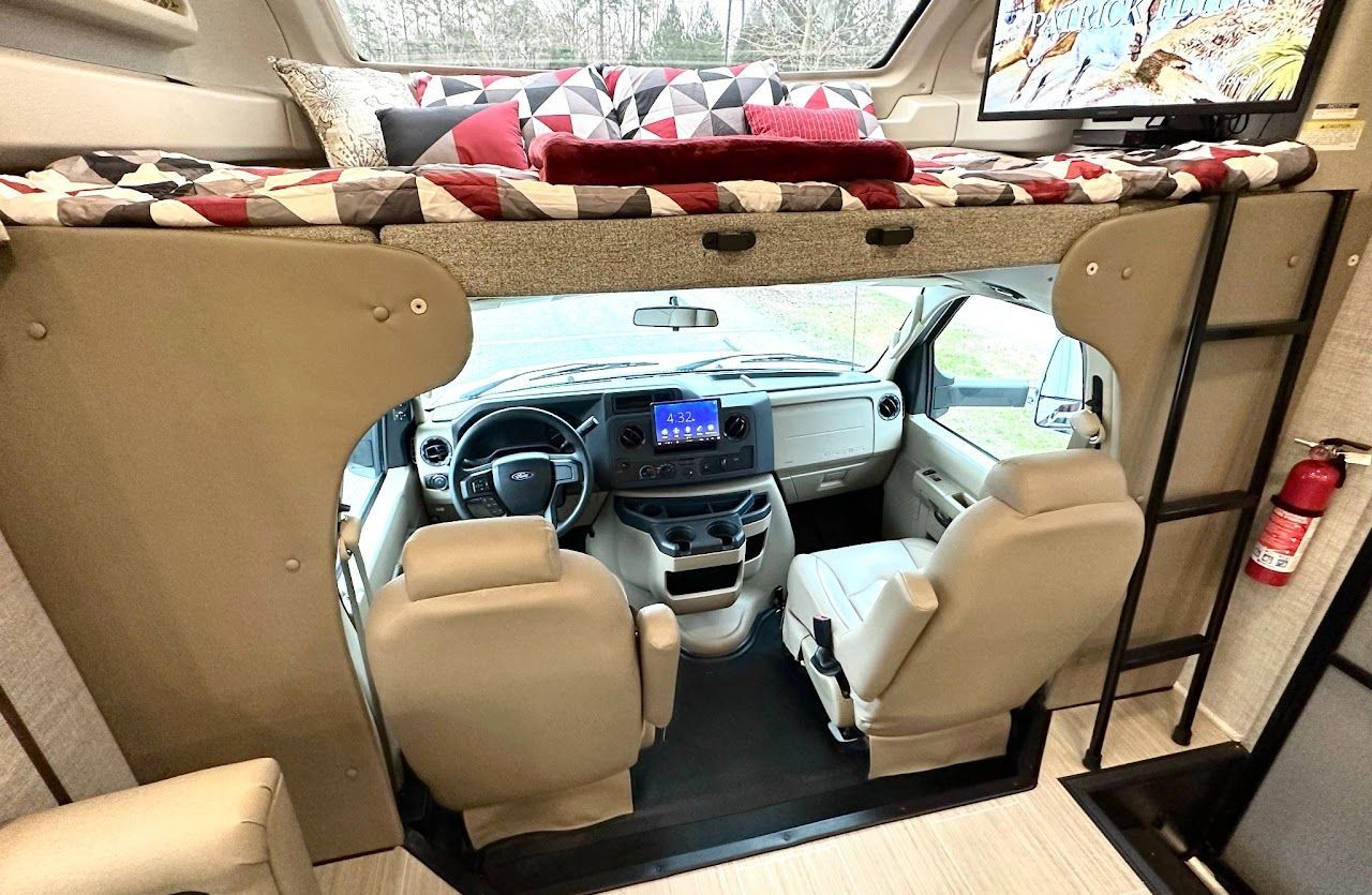 The inside of a rv with a bunk bed and a television.
