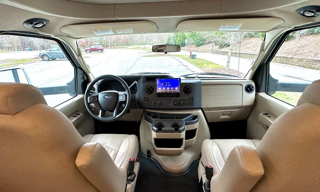 The inside of a van with two seats and a steering wheel.